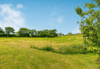 Prairie verdoyante avec ciel bleu et arbres près du pod Worm Dale au Royaume-Uni.