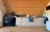 Moderne kitchenette in Deep Dale-pod, VK, met houten plafond, compacte toestellen en keukengerei.