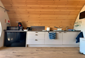 Moderne kitchenette in Deep Dale-pod, VK, met houten plafond, compacte toestellen en keukengerei.