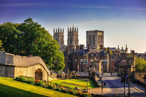 Scenic city view of York with historic walls, lush greenery, and the iconic York Minster in the background.