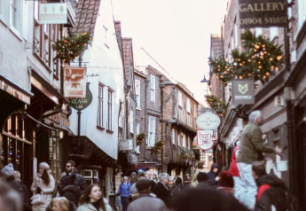 Gezellige oude winkelstraat met veel mensen, traditionele gevels en feestelijke kerstversiering.