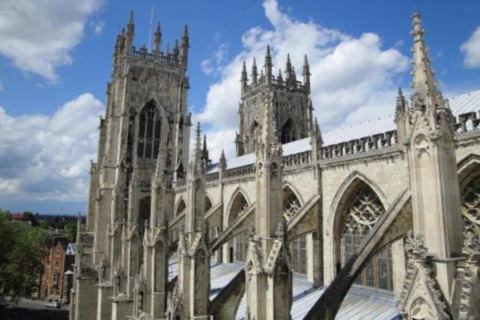 View of a Gothic cathedral with tall towers and ornate stone carvings, seen from a viewing platform or pod.