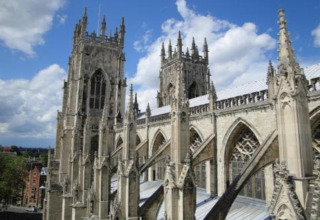 View of a Gothic cathedral with tall towers and ornate stone carvings, seen from a viewing platform or pod.