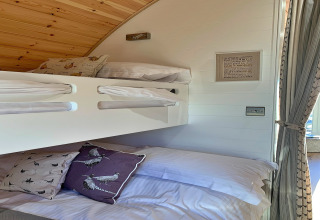 Moderne køjesenge i en hyggelig pod med træloft, bløde puder og naturligt lys ved Mingle Dale, UK.