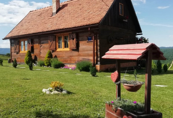 Chalet Stara Hiža Vlašić met privé tuin, houten huisje en bloempotten op de voorgrond.