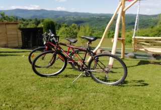 Twee fietsen op gras voor een schommel met berguitzicht bij chalet Stara Hiža Vlašić, Kroatië.