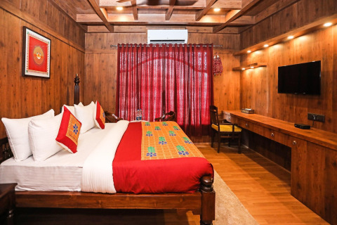 Camera in legno con letto matrimoniale, TV a parete e decorazioni vivaci su Ekta Houseboat Statue Of Unity.