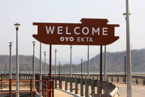 Willkommensschild am Ekta Houseboat bei der Statue of Unity, umgeben von Bergen und Gehweg.