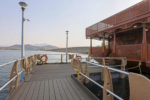 Vista de una casa flotante decorada en el muelle junto al agua y montañas cerca de la Estatua de la Unidad.