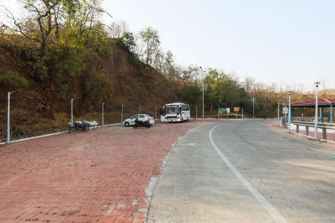 Parkplatz an der Ekta Houseboat Statue Of Unity Kevadia mit Bus, Autos und umliegender Natur.