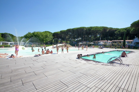 Buitenzwembad bij het Luna Pineta mobilhome in Italië met gasten die genieten van een zonnige dag.