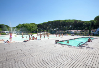 Buitenzwembad bij het Luna Pineta mobilhome in Italië met gasten die genieten van een zonnige dag.