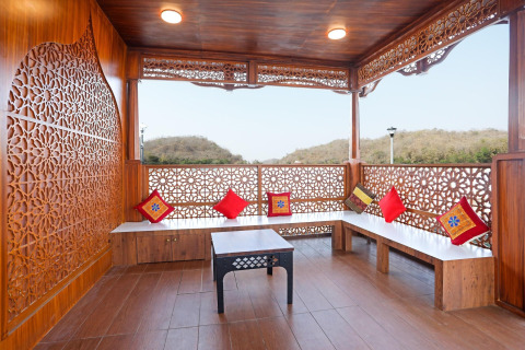 Veranda in legno su Ekta Houseboat Statue Of Unity Kevadia con cuscini vivaci e vista panoramica sulle colline.