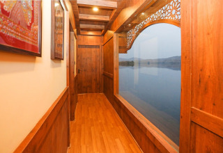 Corridoio in legno su Ekta Houseboat Statue Of Unity Kevadia con ampia finestra vista lago a destra.