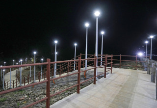 Beleuchteter Gehweg mit Geländer und Straßenlaternen bei Nacht nahe Ekta Houseboat, Statue Of Unity.