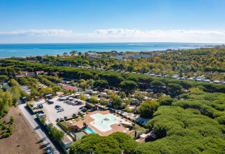 Luchtfoto van het Luna Pineta mobilhome in Italië, omgeven door pijnbomen en dicht bij het strand en de zee.