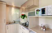 Moderne kitchenette in mobilhome Cottage Cesenatico in Italië met kookplaat, gootsteen en magnetron.