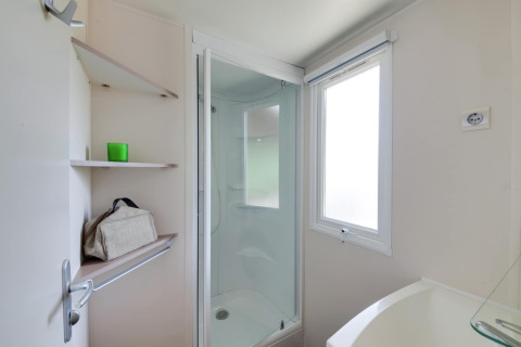 Badezimmer im Mobilheim Cottage «Cesenatico» mit Dusche, Regal und Fenster in Italien.