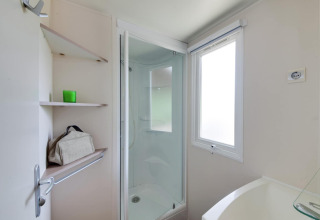 Baño en la casa móvil Cottage «Cesenatico» en Italia con ducha, estantes y ventana esmerilada.