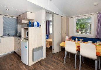 Interieur van mobilhome Cottage 'Cesenatico' in Italië met keuken en gezellige eetruimte.
