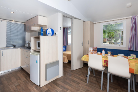 Interior de la casa móvil Cottage 'Cesenatico' en Italia con cocina y comedor luminoso.