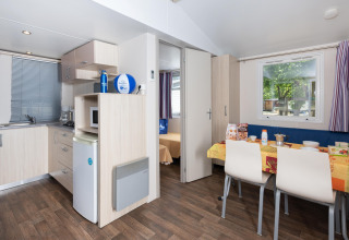 Modernes Mobilheim Cottage 'Cesenatico' in Italien mit Küchenzeile und gemütlichem Essbereich.