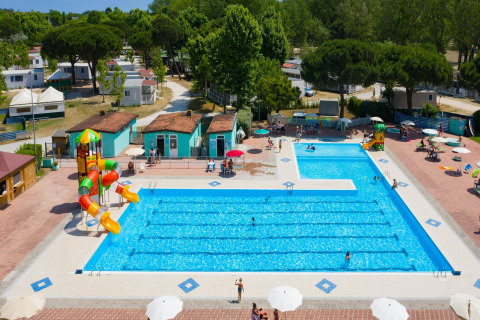 Vista aérea de piscina con toboganes de agua y casas móviles en Cottage «Cesenatico» en Italia.