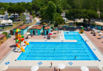 Vista aérea de piscina con toboganes de agua y casas móviles en Cottage «Cesenatico» en Italia.
