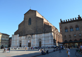 Basiliek van San Petronio aan het Piazza Maggiore in Bologna, Italië, met mensen op het plein.