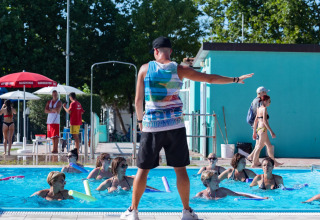 Un instructor dirige una clase de aquagym en la piscina exterior del Cottage «Cesenatico» en Italia.