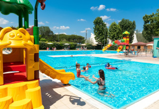 Niños jugando en una piscina al aire libre con toboganes en Cottage Cesenatico, Italia, en un día soleado.