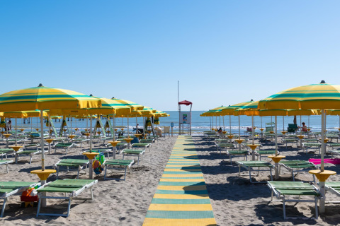 Sillas de playa y sombrillas amarillas en la playa de Cesenatico, Italia, vistas desde la casa móvil Cottage.