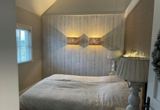 Bedroom at Holiday Home De Vlonder, Netherlands, featuring cozy lighting, double bed, and window view.