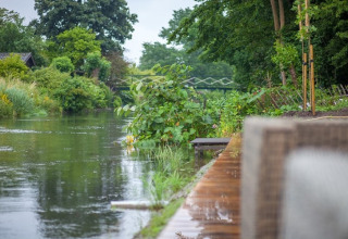 Udsigt over en fredelig flod omgivet af frodig grøn vegetation nær Holiday home De Vlonder i Holland.