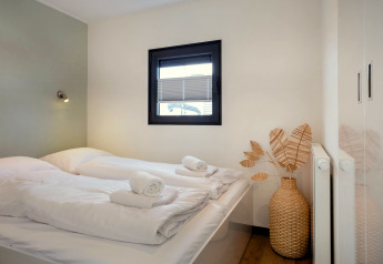 Chambre lumineuse et moderne sur la péniche «Agua Dolce» aux Pays-Bas avec lits jumeaux et décoration sobre.