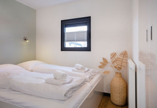 Helles Schlafzimmer im Hausboot «Agua Dolce» in den Niederlanden mit Doppelbett und stilvoller Dekoration.