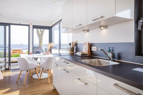Moderne Küche und Essbereich im Hausboot «Agua Dolce» mit Blick aufs Wasser in den Niederlanden.