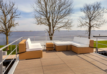 Dachterrasse des Hausbootes «Agua Dolce» in den Niederlanden mit Blick auf das Wasser und gemütlichen Möbeln.