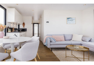 Modernes Wohnzimmer und Küche im Hausboot 'Agua Dolce' in den Niederlanden mit hellen Möbeln.