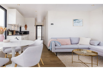 Soggiorno e cucina moderni nella houseboat 'Agua Dolce' nei Paesi Bassi con arredi chiari.