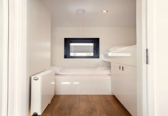 Helles, modernes Schlafzimmer mit Etagenbetten und Holzboden auf dem Hausboot 'Agua Dolce' in den Niederlanden.