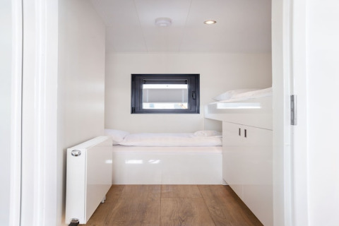 Helles, modernes Schlafzimmer mit Etagenbetten und Holzboden auf dem Hausboot 'Agua Dolce' in den Niederlanden.