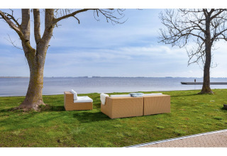 Outdoor-Loungebereich mit Sofas am Seeufer, gesehen vom Hausboot 'Agua Dolce' in den Niederlanden.