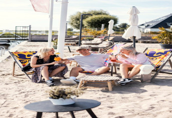 Drei Freunde entspannen auf bunten Liegestühlen vor dem Hausboot «Agua Dolce» in den Niederlanden.