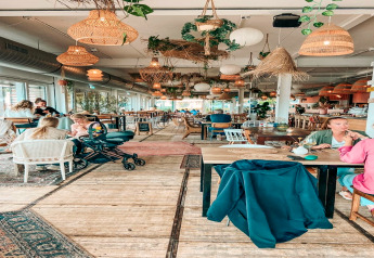 Helles, gemütliches Café auf dem Hausboot «Agua Dolce» mit Gästen und Pflanzen in den Niederlanden.