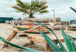 Gemütliche Mahlzeit mit Getränken am Strand auf dem Hausboot 'Agua Dolce', Niederlande.