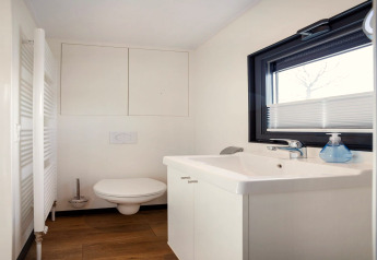 Modernes Badezimmer auf dem Hausboot 'Agua Dolce' in den Niederlanden mit WC, Waschbecken und Fenster.