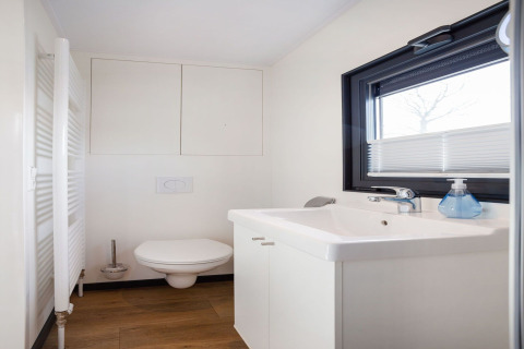 Modernes Badezimmer auf dem Hausboot 'Agua Dolce' in den Niederlanden mit WC, Waschbecken und Fenster.