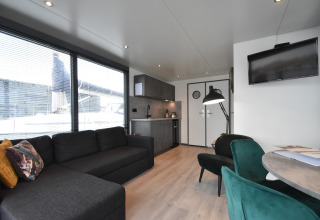Modern living room and kitchen on houseboat 'Boat' in the Netherlands with large windows and decor.