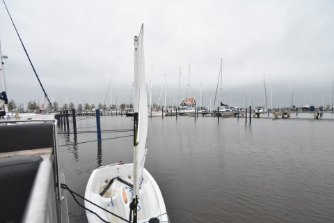View from houseboat 'Boat' in the Netherlands showing a small docked boat and yachts in the marina.